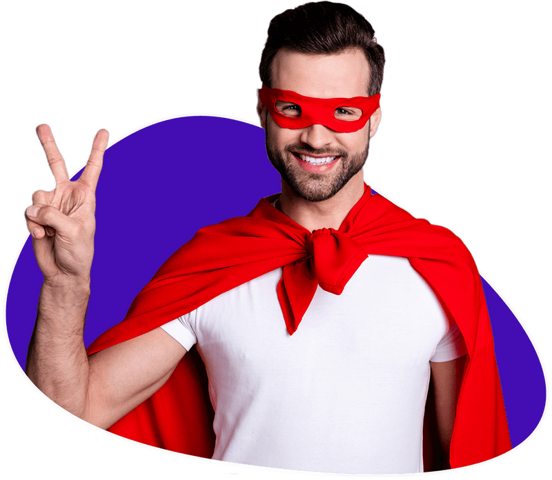 Zu sehen ist ein junger Mann, der ein totes Cape und eine rote Maske trägt. Er macht das Peace-Zeichen und freut sich